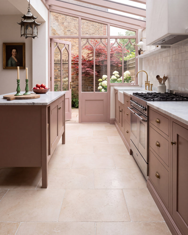 Bergamo Limestone Lightly Seasoned Finish 60 x 40cm flagstones in a glazed side-return galley kitchen with dusky pink cabinetry and Gothic arched doors onto the garden