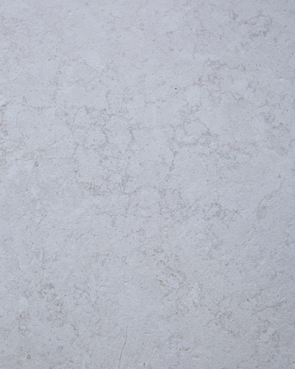 Close-up of the Brit Stone Minster Porcelain surface, showing its soft pale limestone tone and fine mottled veining