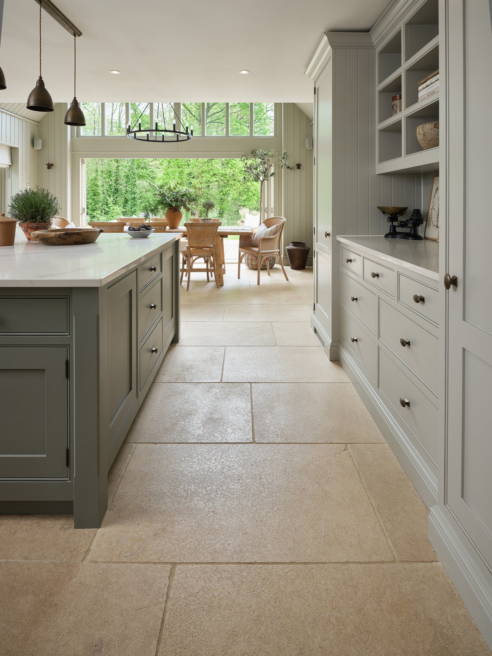 Buscot Limestone Tumbled & Etched flagstones leading from a galley kitchen out to a garden terrace