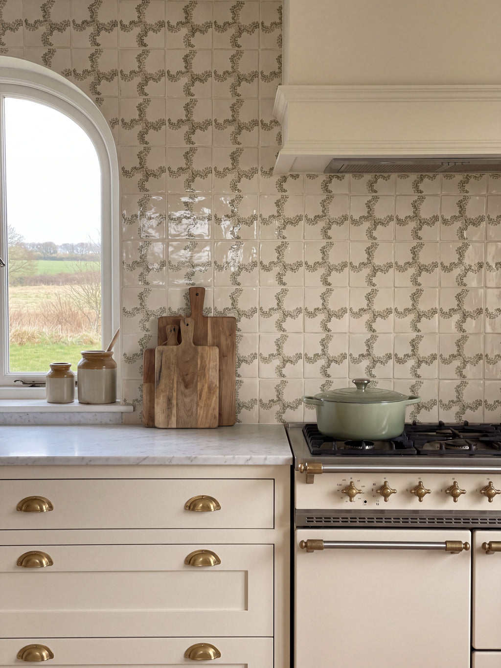 Cream kitchen with Oxbow Check Olive tile splashback, marble worktop, brass cup handles and range cooker