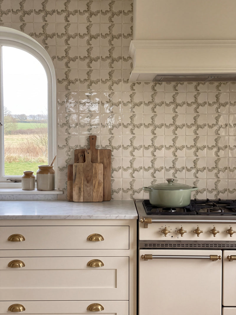 Cream kitchen with Oxbow Check Olive tile splashback, marble worktop, brass cup handles and range cooker