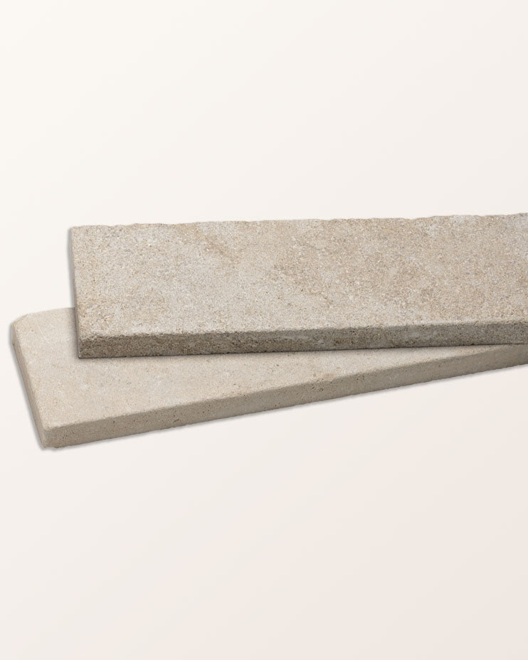 Two Castilan Limestone Parquet Tumbled batons stacked at an angle against a plain background, showing the tumbled edge and the pale honeyed surface