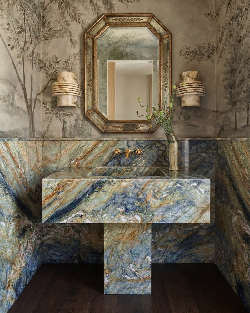 Coral Reef Quartzite Slab in a cloakroom, its blue, green and amber veining running through a floating basin and full-height wall panels beneath a hand-painted landscape mural