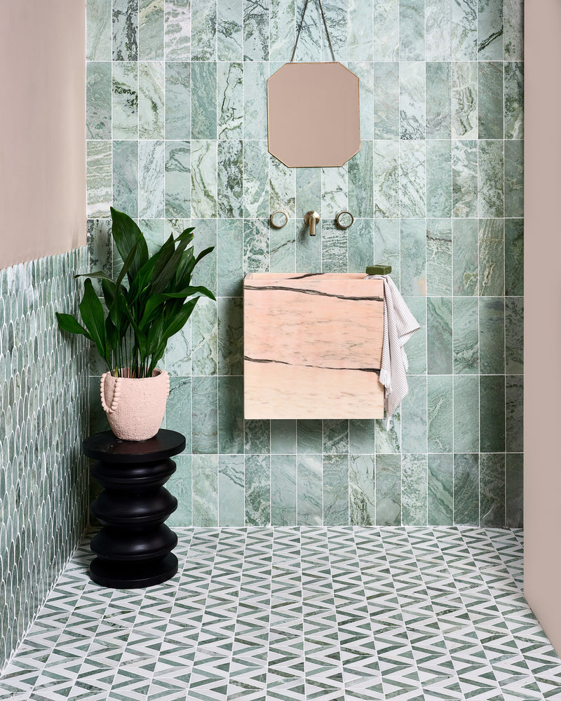 East Java Hummingbird Marble Honed Brick across a cloakroom wall with East Java Hummingbird Marble Plume Mosaic on the return wall and Temple Mosaic underfoot, a bespoke Calacatta Candy basin, an octagonal mirror and a black turned stool