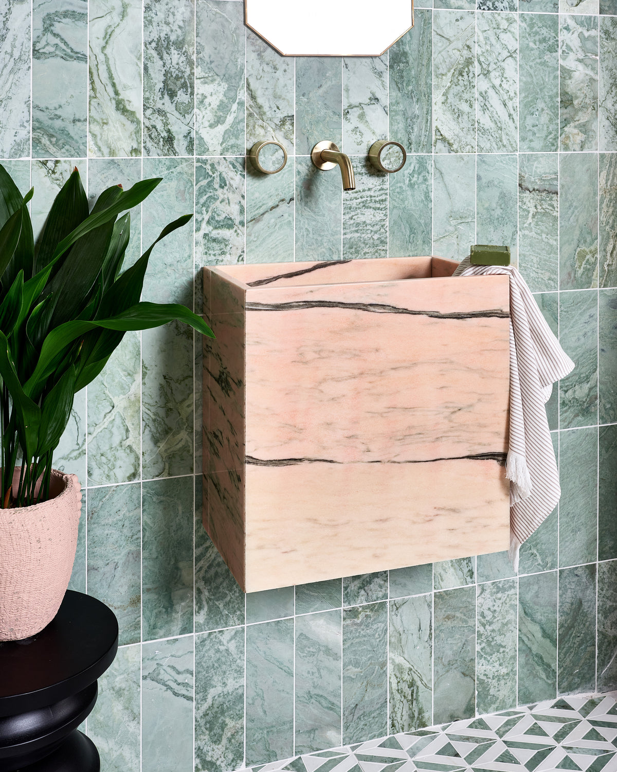 East Java Hummingbird Marble Honed Brick stacked vertically up a cloakroom wall behind a bespoke Calacatta Candy pink marble basin, with brass wall taps and an East Java Hummingbird Marble Temple Mosaic floor