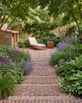 Flanders Warm Russet Tumbled Clay Pavers as a gravel-banded stepping path through lavender and salvia borders, leading to a herringbone terrace with a sun lounger