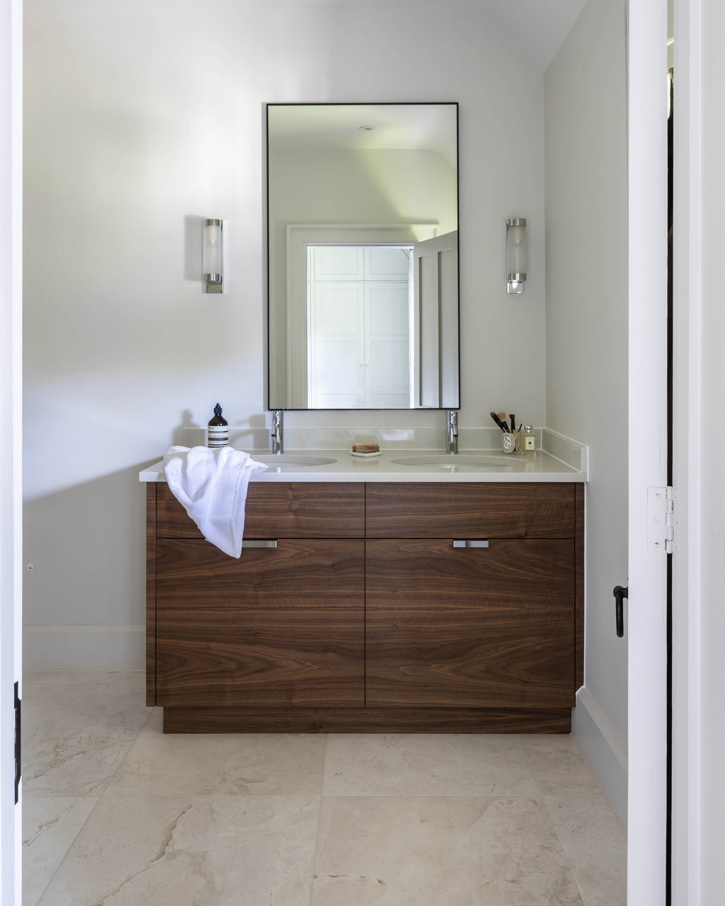 Folio Marble Honed Finish floor in a compact ensuite with a walnut double vanity set under a sloped ceiling