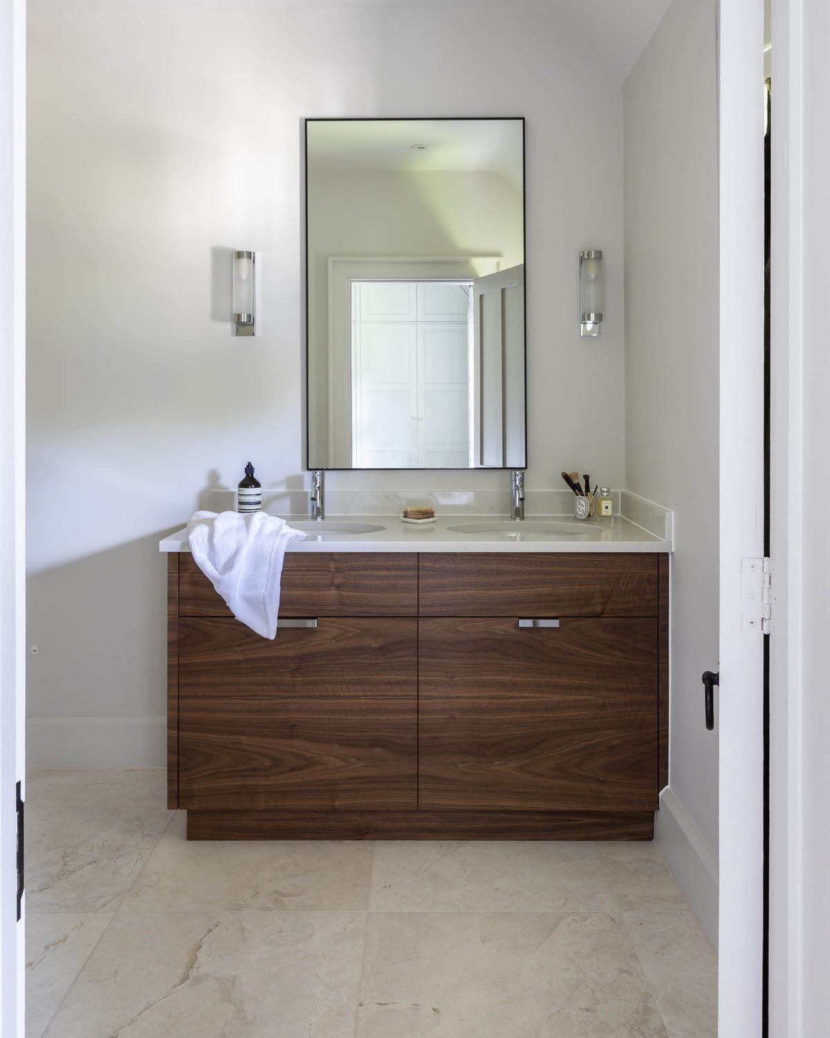 Folio Marble Honed Finish floor in a compact ensuite with a walnut double vanity set under a sloped ceiling