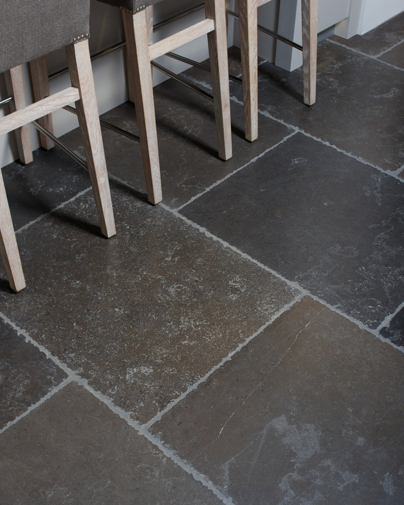Hazlebury Limestone Seasoned Finish laid in large format beneath limed oak bar stools at a kitchen island