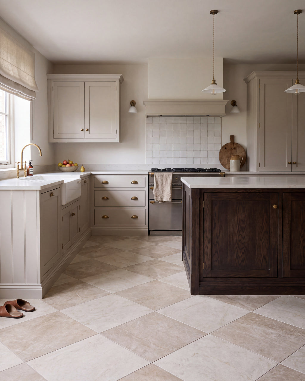 Hoxton Porcelain Amber Matt laid diagonally with Hoxton Porcelain Linen Matt in a chequerboard across a shaker kitchen floor, with a dark oak island, brass cup handles and a range cooker