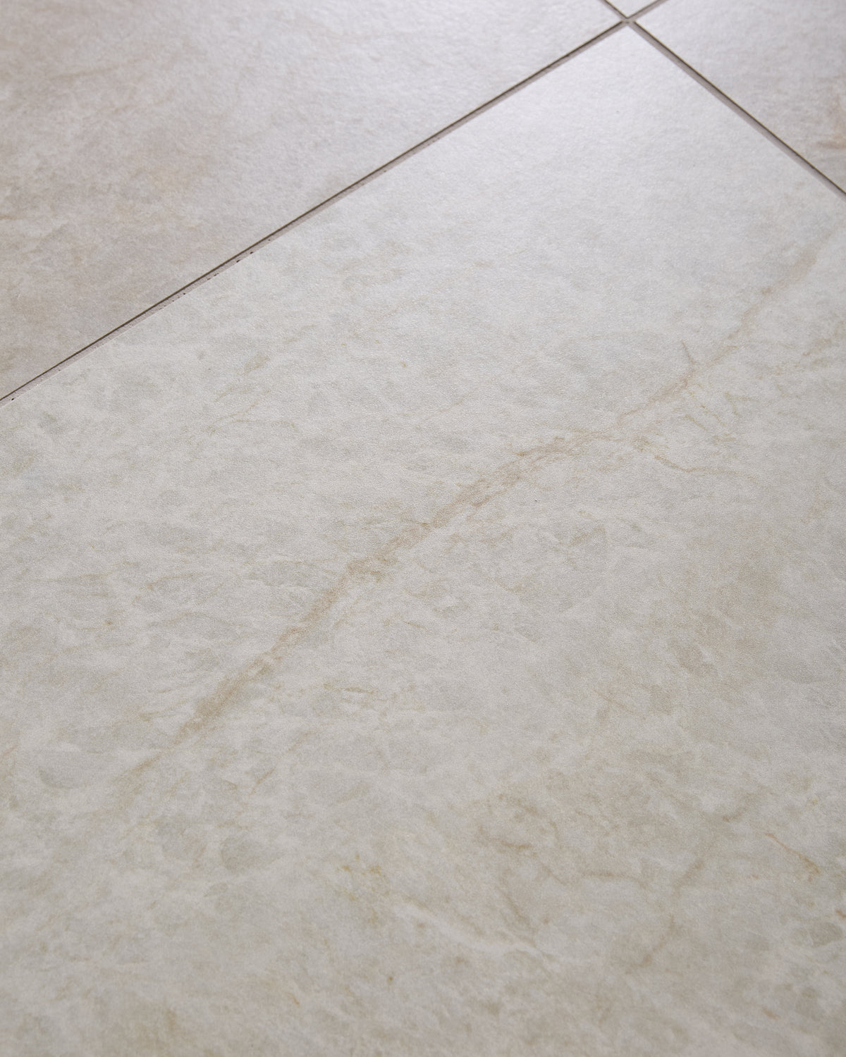Hoxton Porcelain Linen Matt shown close up across a single large tile, with the pale linen surface and warm sandy veining running diagonally through it
