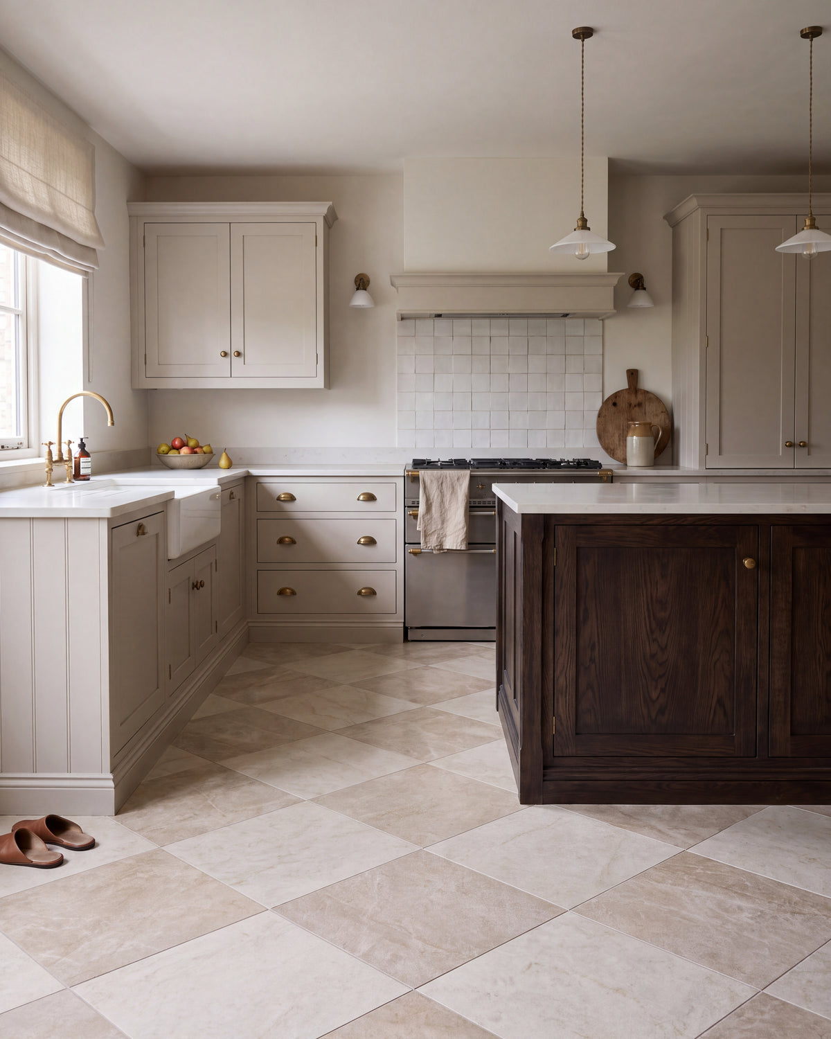 Hoxton Porcelain Linen Matt laid diagonally with Hoxton Porcelain Amber Matt in a chequerboard across a shaker kitchen floor, with a dark oak island, brass cup handles and a range cooker