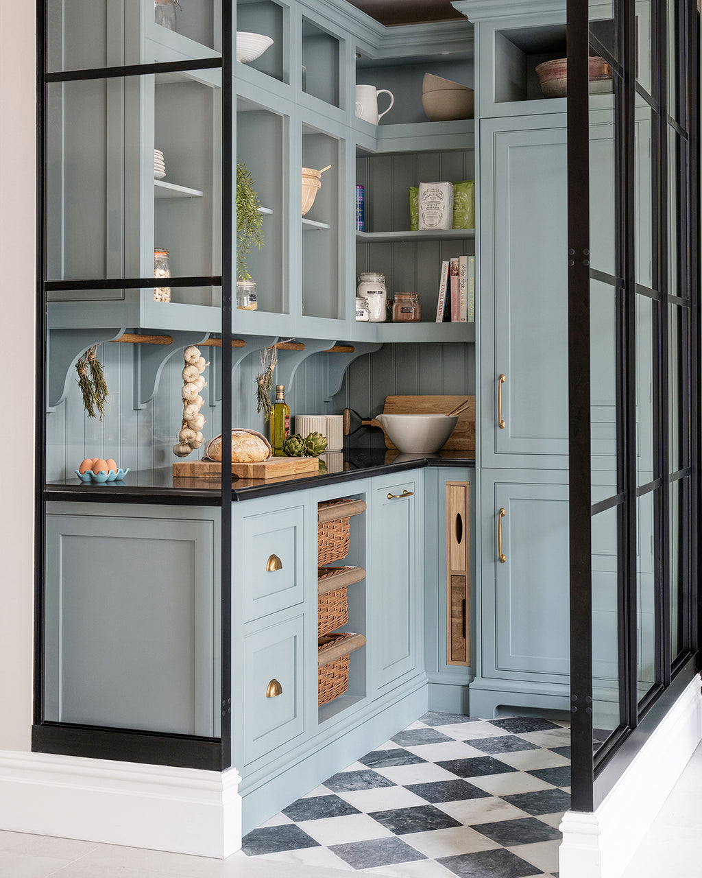 Kendal Marble Tumbled Finish chequerboard floor running into a pale blue walk-in pantry behind black Crittall-style glazing