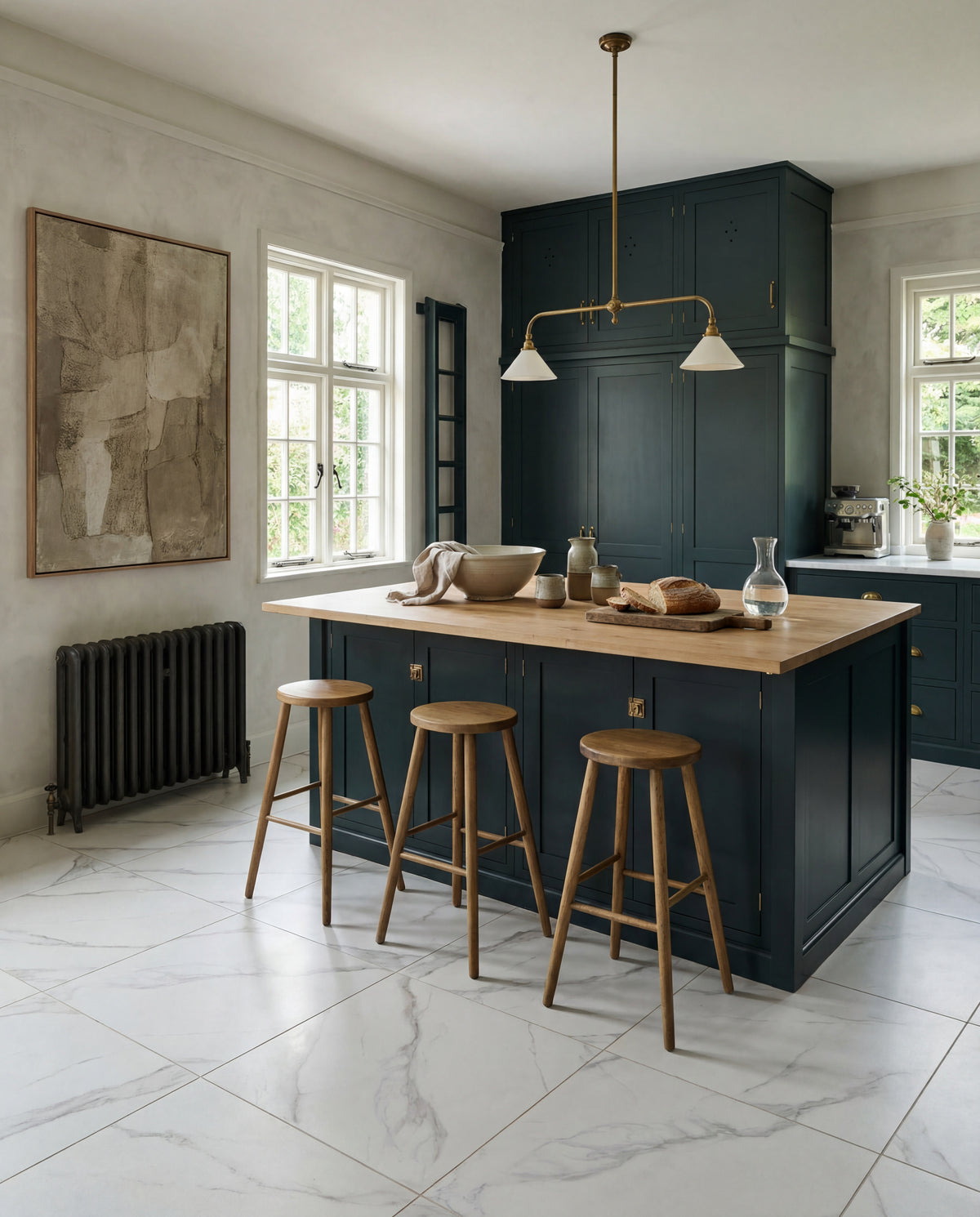 Kensington Porcelain Matt laid across a kitchen floor with a dark blue island, oak worktop and brass lighting