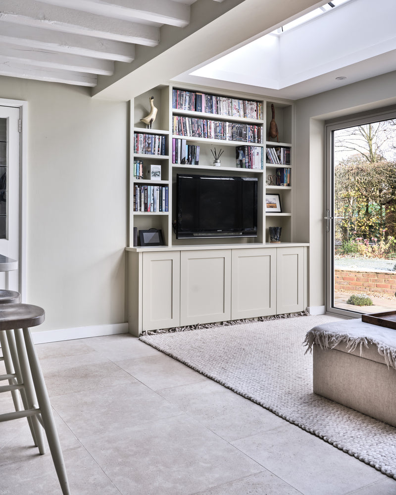 Kimmeridge Limestone Etched Finish across a snug beneath a skylight, with built-in bookshelves, a woven rug and garden doors open onto a brick terrace