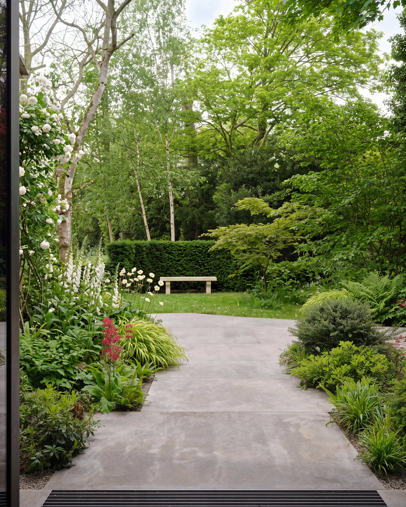 Kimmeridge Limestone Paving Etched Finish in large format slabs, forming a path from open glazed doors past white roses and foxgloves to a lawn and stone bench