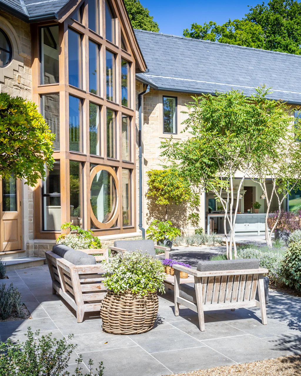 Kimmeridge Limestone Paving Tumbled & Etched Finish across a sheltered courtyard seating area beneath an oak-framed gable window