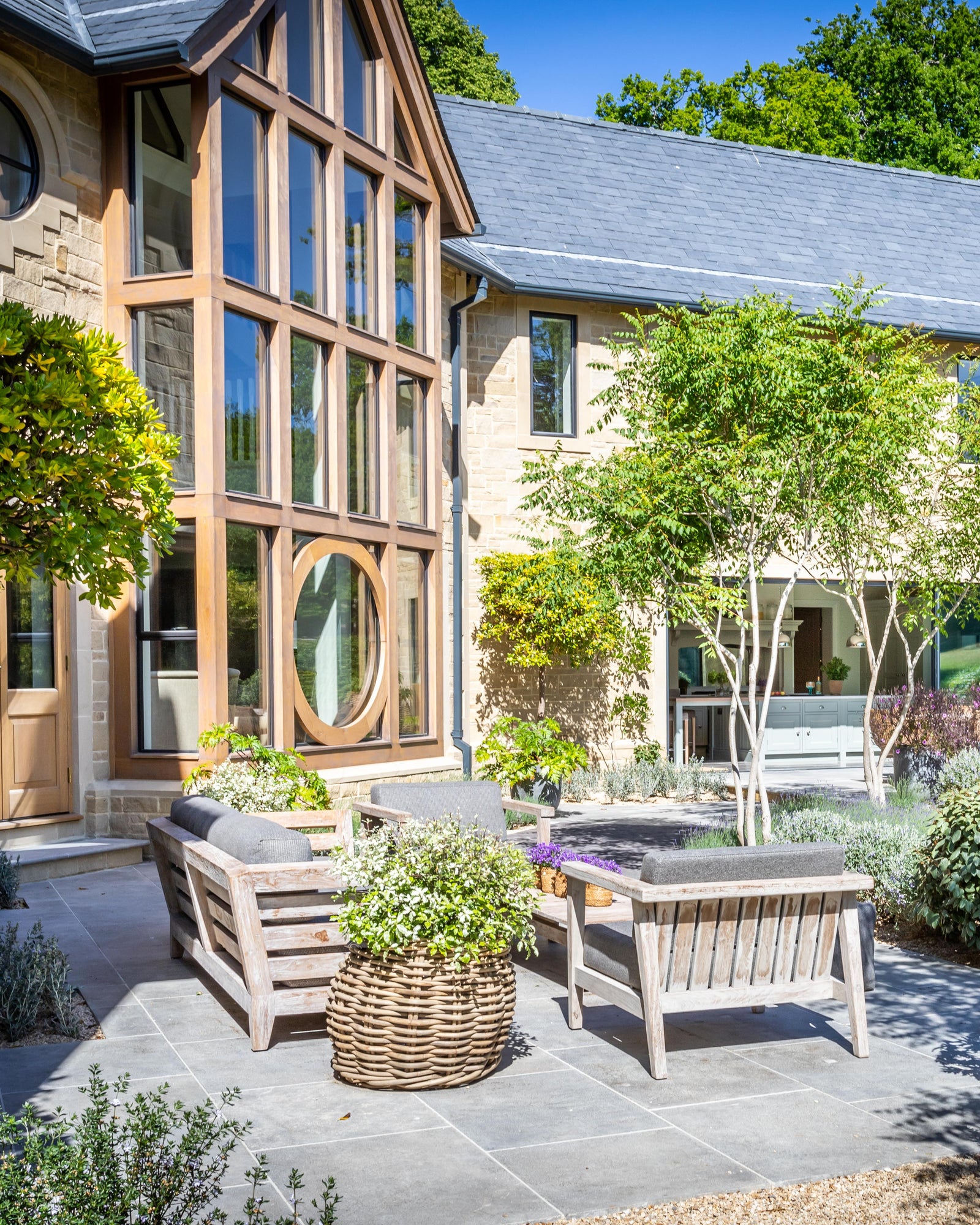 Kimmeridge Limestone Paving Tumbled & Etched Finish across a sheltered courtyard seating area beneath an oak-framed gable window