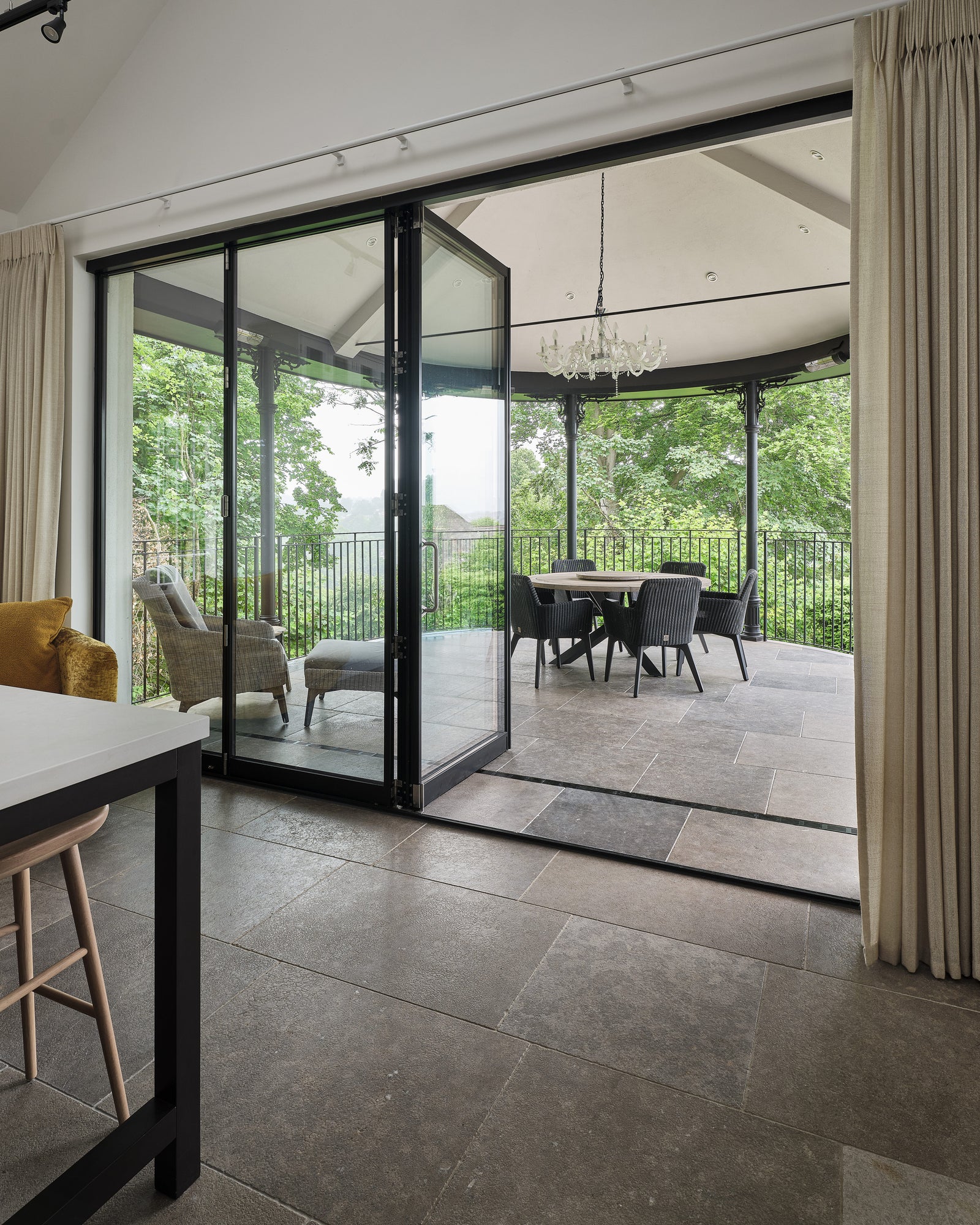 Kimmeridge Limestone Tumbled & Etched Finish running from a kitchen floor straight out through open sliding doors onto the veranda beyond