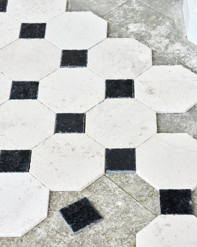 Limoges Limestone Vintaged Finish octagons set with Tora Blue Vintaged Cabochons, laid loose over outdoor flagstones to show the pattern