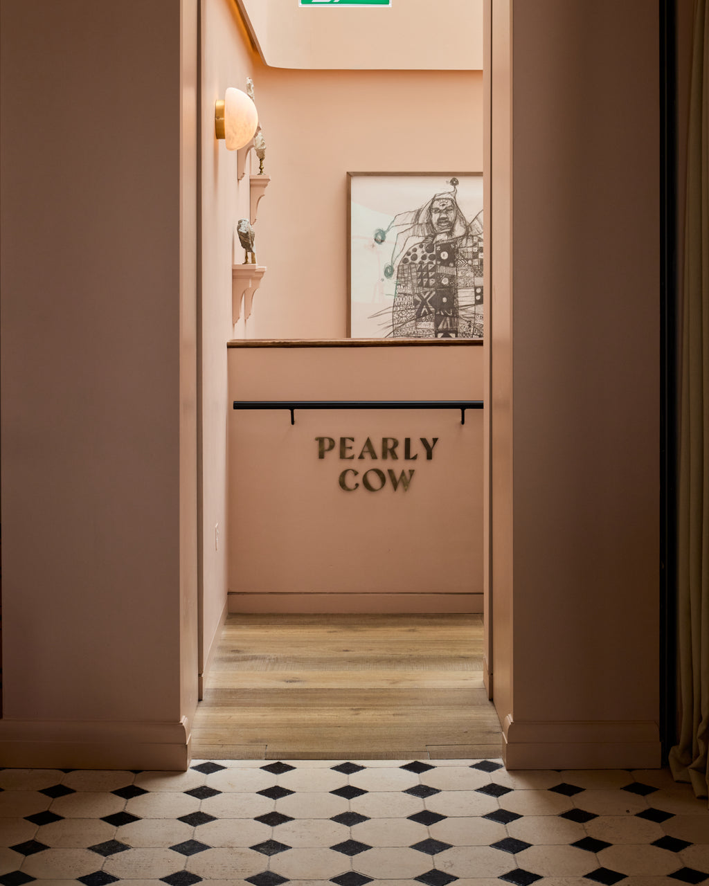 Limoges Limestone Vintaged Finish octagons with Tora Blue cabochons running up to a pink painted doorway at the Pearly Cow restaurant