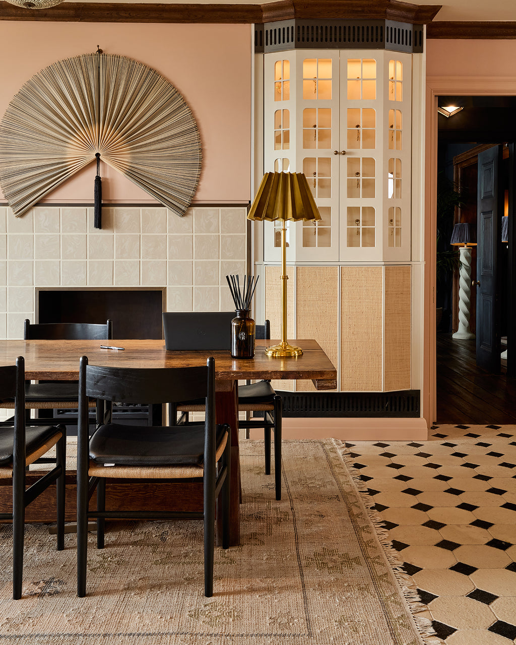 Limoges Limestone Vintaged Finish octagon floor beside a dining table in a pink panelled room with a woven fan wall piece