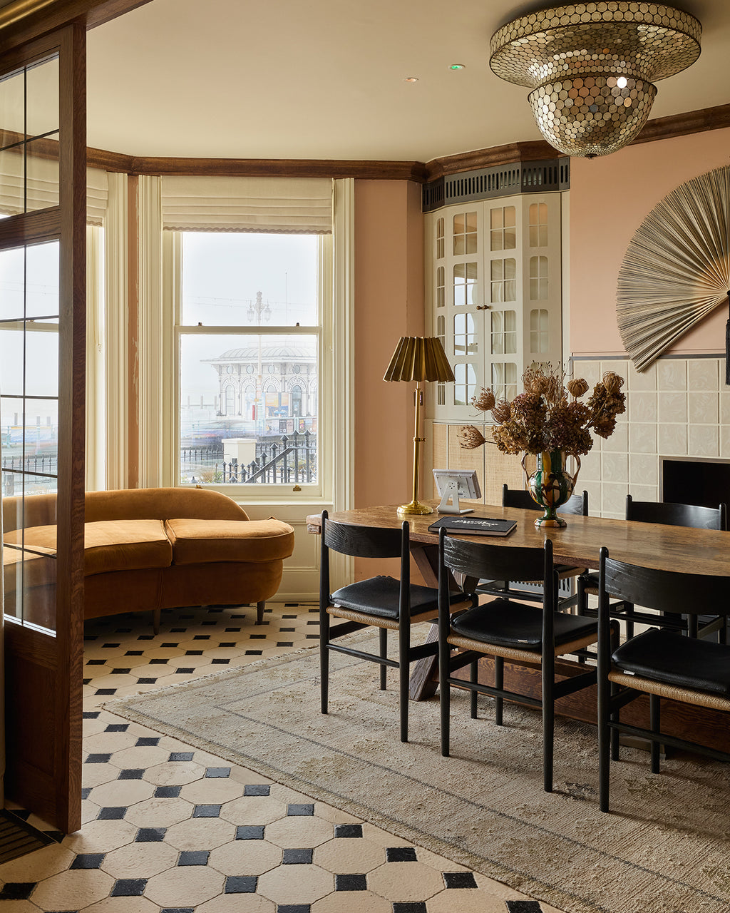 Limoges Limestone Vintaged Finish octagons and Tora Blue cabochons across a bay window dining room looking out over the seafront