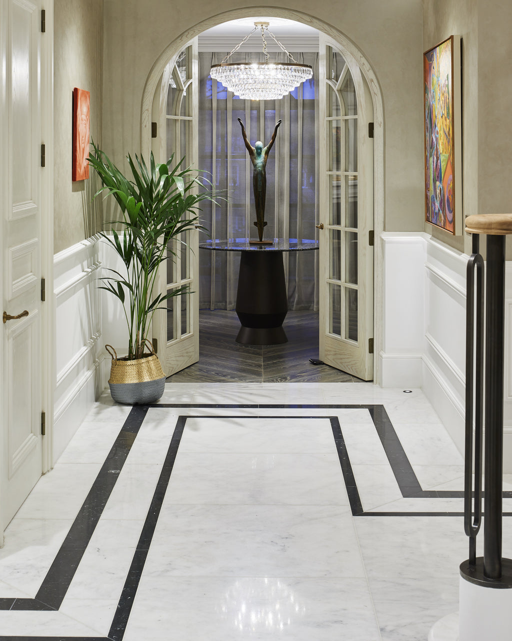 Long Island Marble Honed Finish flooring with a black inlay border in a panelled hallway leading to an arched doorway