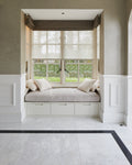Long Island Marble Honed Finish flooring and black border running up to a built-in window seat with linen cushions
