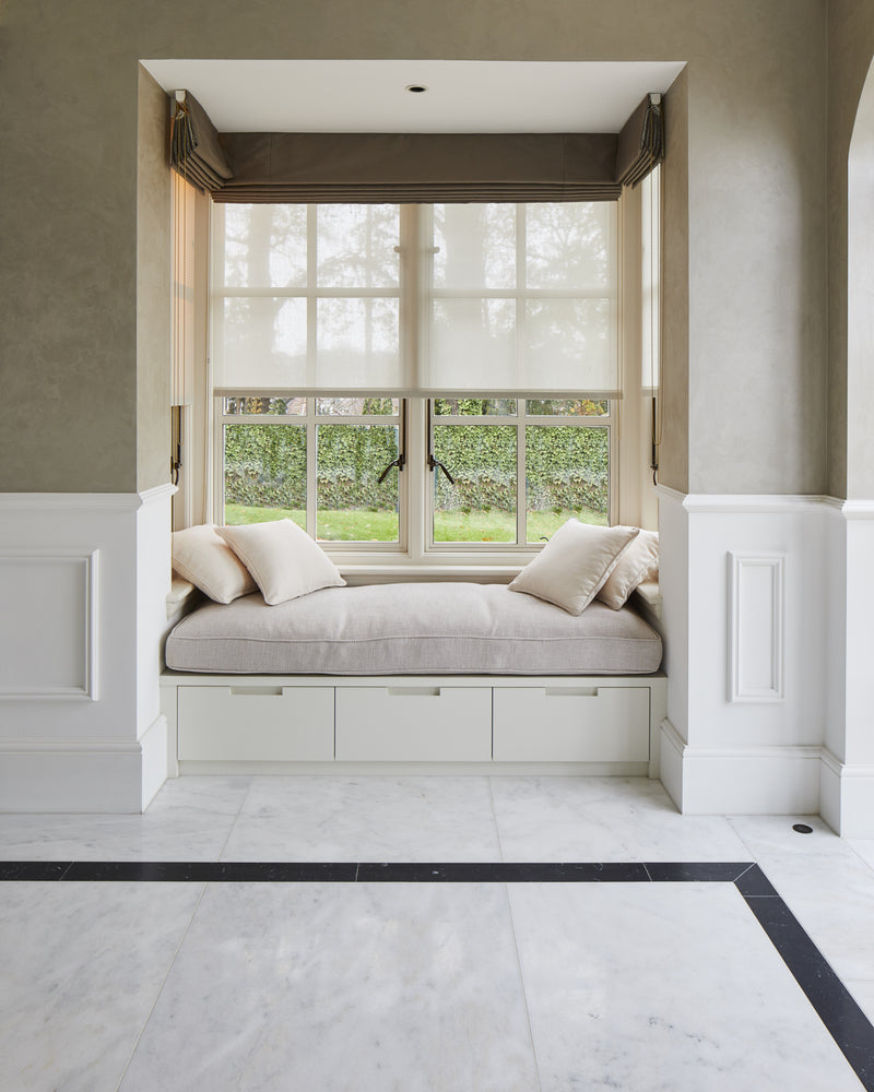 Long Island Marble Honed Finish flooring and black border running up to a built-in window seat with linen cushions