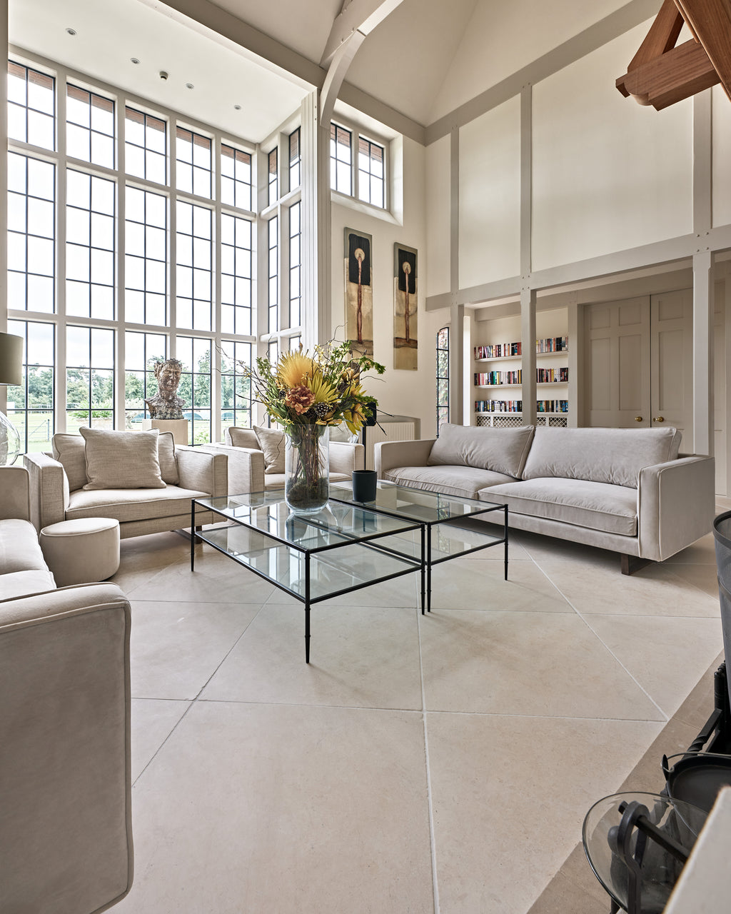 Mallory Limestone Tumbled Finish flagstones across a double-height drawing room with tall steel windows and a vaulted oak-trussed ceiling