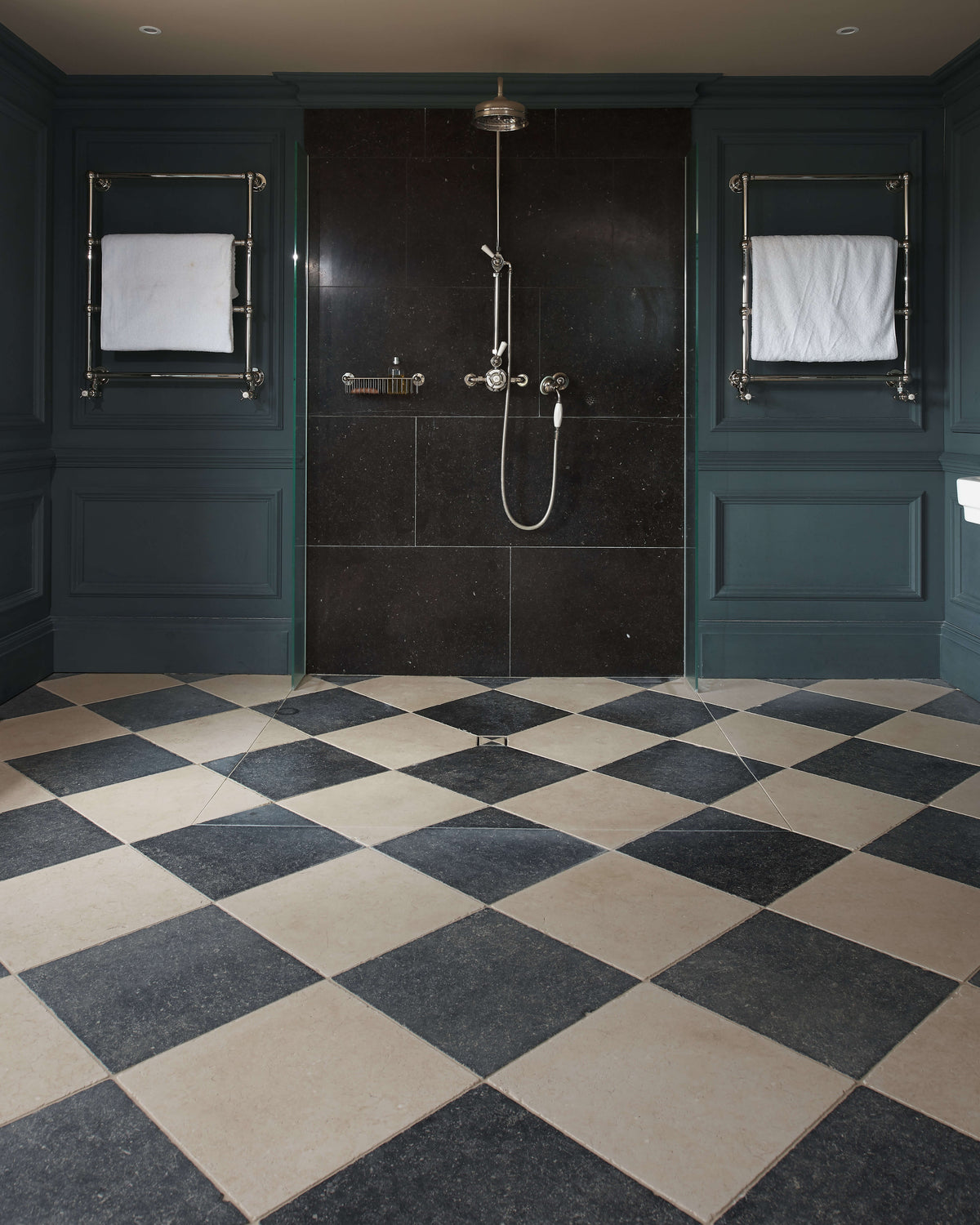 Mallory Limestone Tumbled Finish in a chequerboard with dark limestone across a teal panelled bathroom with a walk-in shower