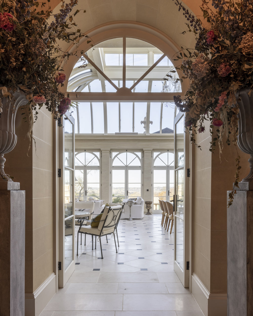 Mallory Limestone Tumbled Finish laid through a stone archway looking into an orangery, with dark cabochon insets beyond