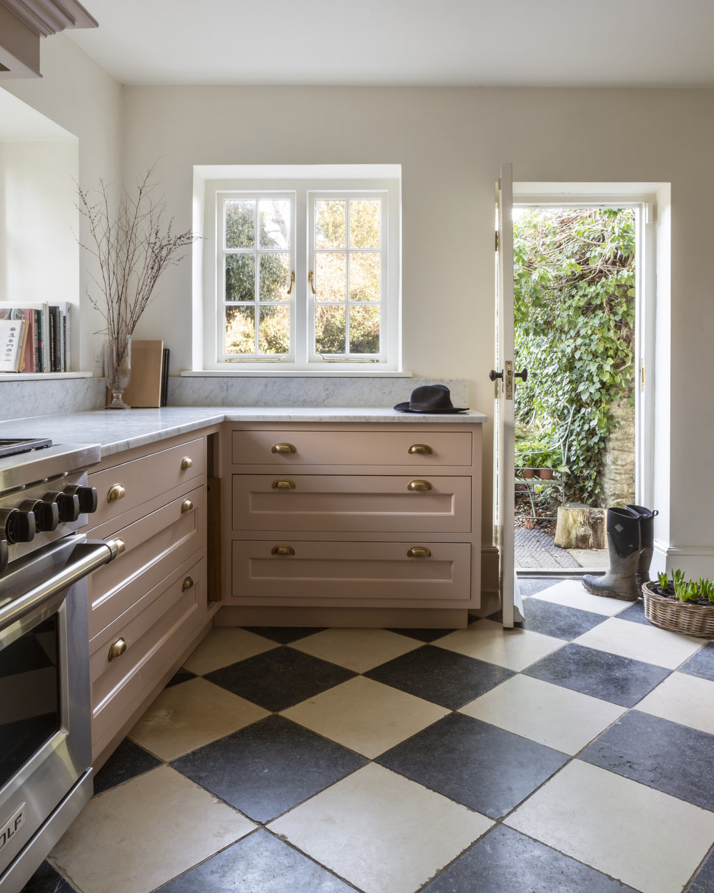 Mallory Limestone Tumbled Finish in a chequerboard with dark limestone across a kitchen floor with pink painted cabinetry and a marble worktop
