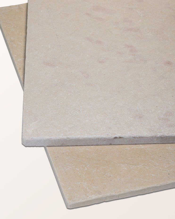 Two tiles of Mallory Limestone Tumbled Finish stacked at an angle, showing the tumbled edge profile and pale cream colour