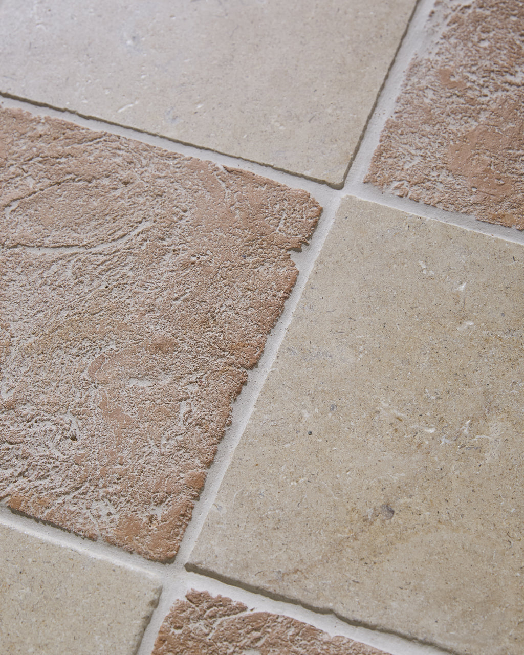 Close-up of Marlborough Terracotta Square against Buscot Limestone Tumbled, showing the tumbled edges, lime-washed surface and fine grout joints of the checkerboard