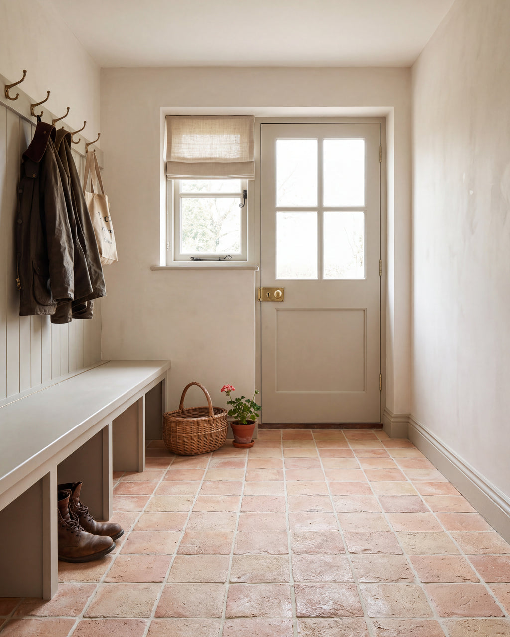 Marlborough Terracotta Square across a boot room floor, with a limewashed panelled bench, brass coat hooks and a stable door to the garden
