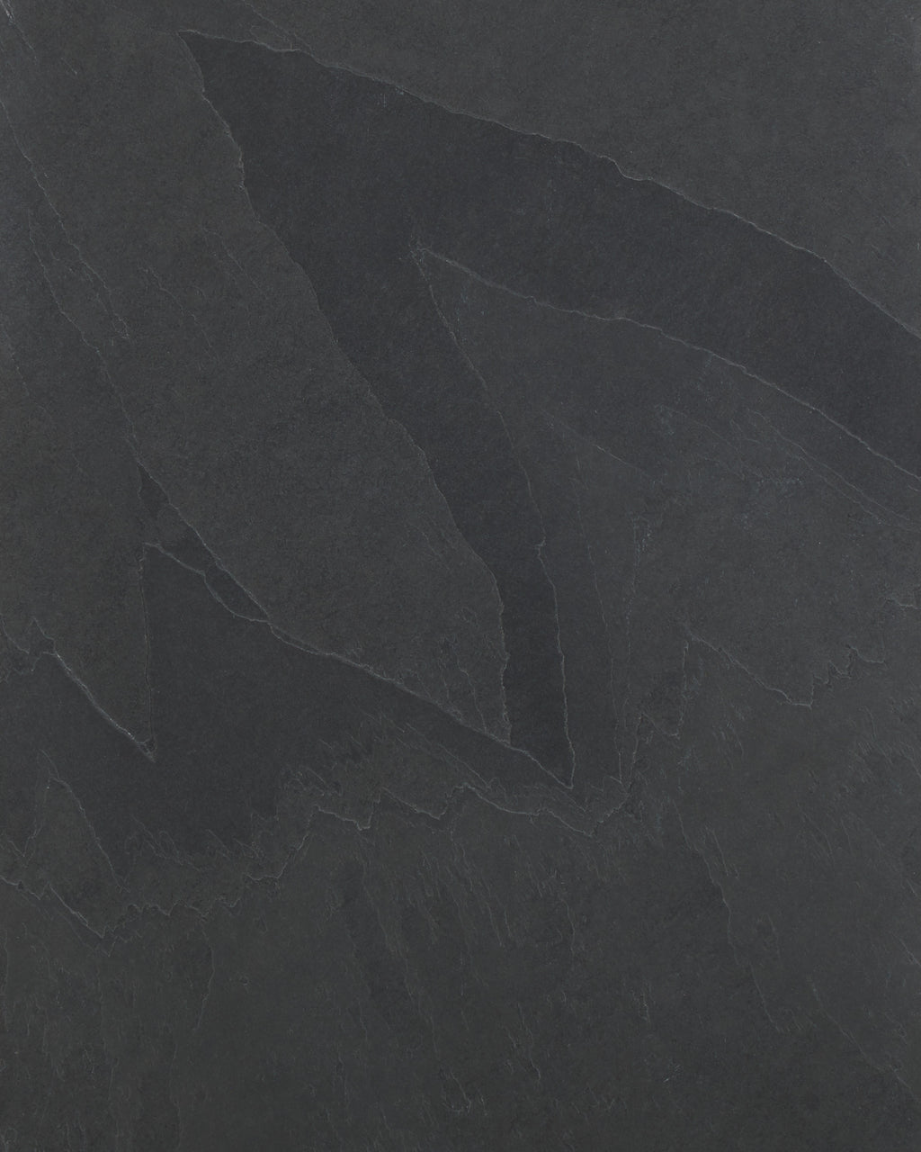 Close-up of the Metropolitan Slate Riven Slab surface, showing the charcoal tone and the cleft ridges and pale seams of the riven finish