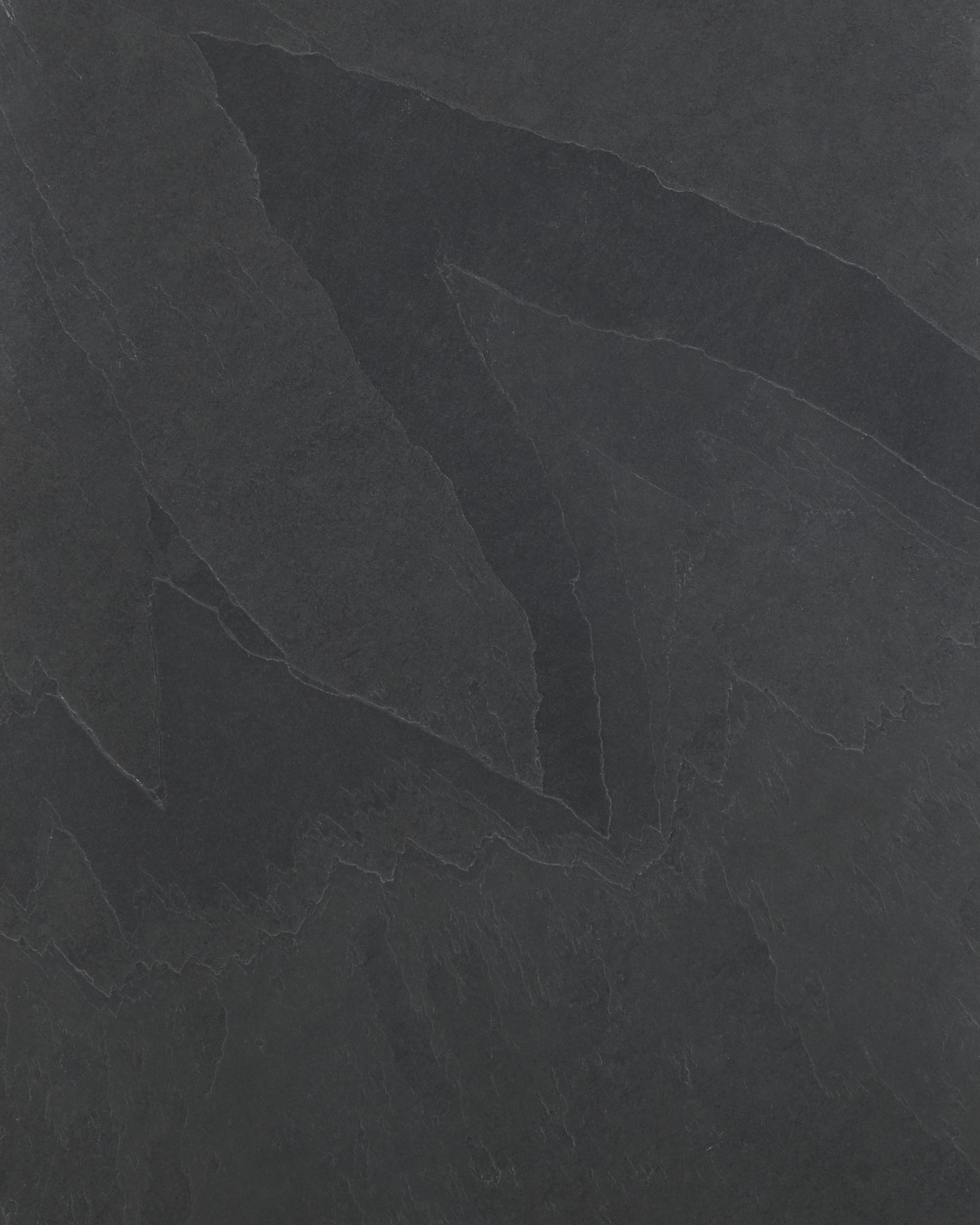 Close-up of the Metropolitan Slate Riven Slab surface, showing the charcoal tone and the cleft ridges and pale seams of the riven finish