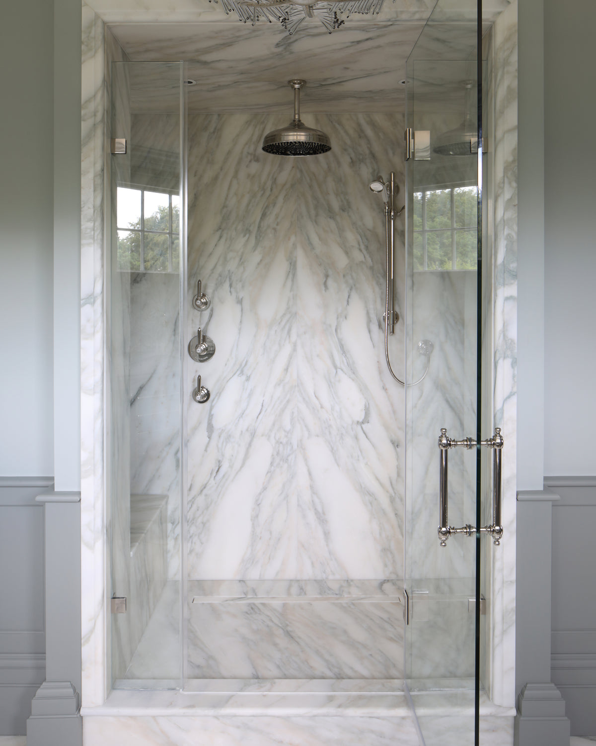Palazzo Oro Marble Honed Slab book-matched across the back wall and ceiling of a glass shower enclosure with polished nickel fittings