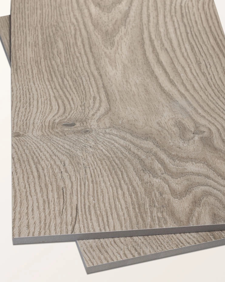Two planks of Parterre Porcelain Plank overlapping at an angle on a plain background, showing the grey oak grain and embossed surface texture