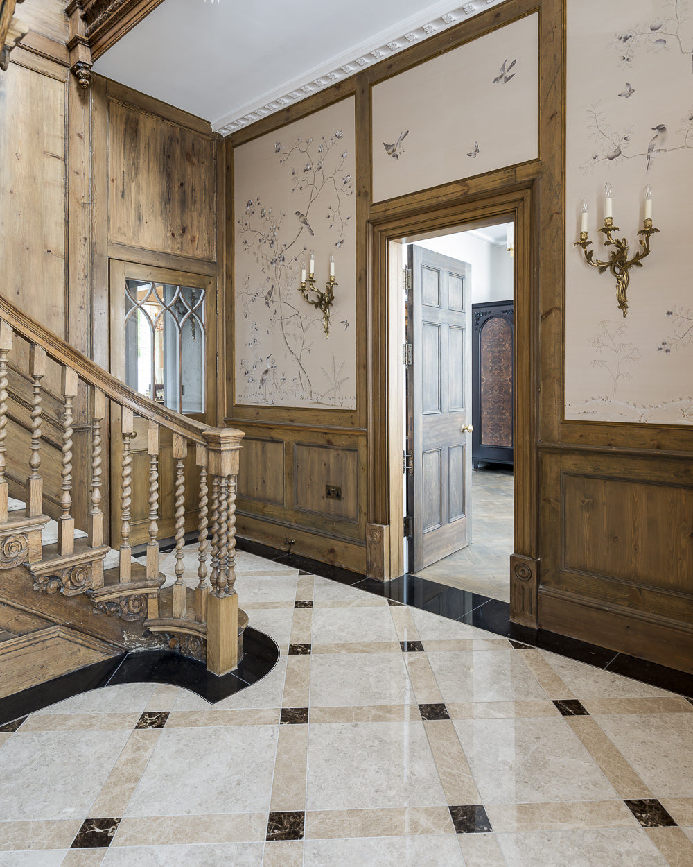 Piccadilly Limestone Honed Finish laid on the diagonal with dark cabochons in a pine panelled hall with hand-painted bird wallpaper