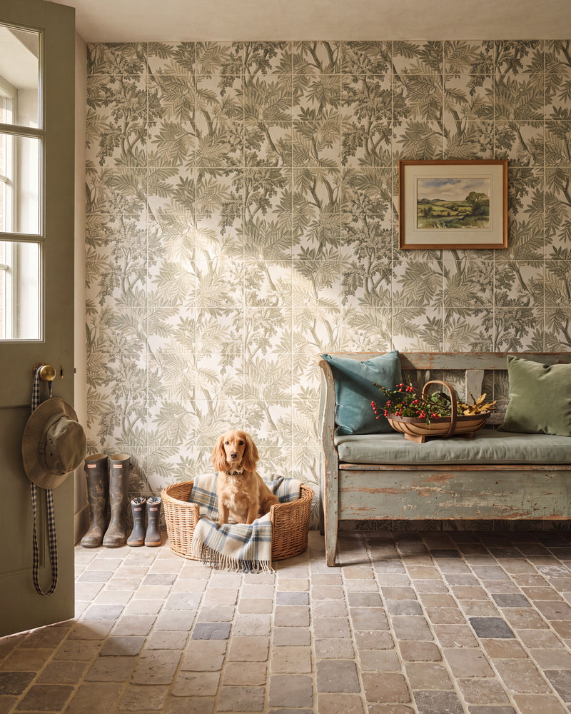 Sanderson Tapestry Trees Forest Mural Porcelain running the full height of a country boot hall, with a spaniel in a wicker basket, wellingtons by a green stable door and a cobbled stone floor