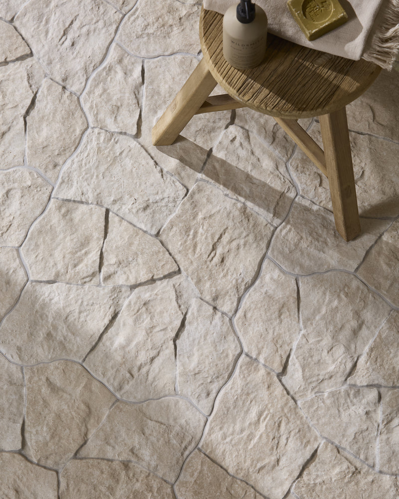 Sierra Porcelain Textured floor with a small teak stool holding hand wash, a bar of soap and a fringed linen towel, in warm daylight