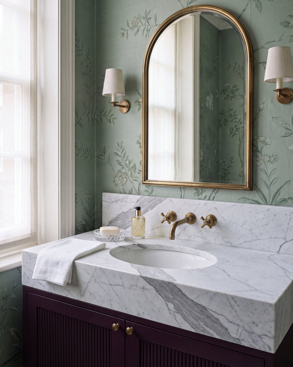 Statuario Marble Slab as a bespoke vanity top with integrated basin and upstand, on a fluted aubergine cabinet against green chinoiserie wallpaper
