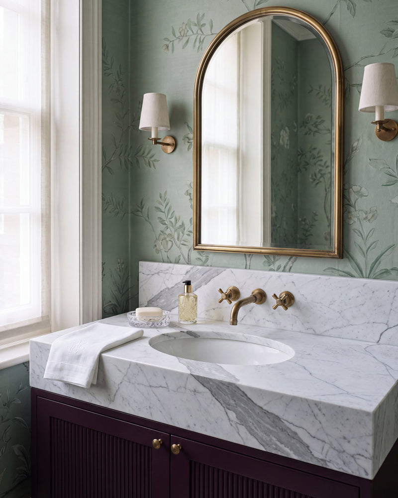 Statuario Marble Slab as a bespoke vanity top with integrated basin and upstand, on a fluted aubergine cabinet against green chinoiserie wallpaper
