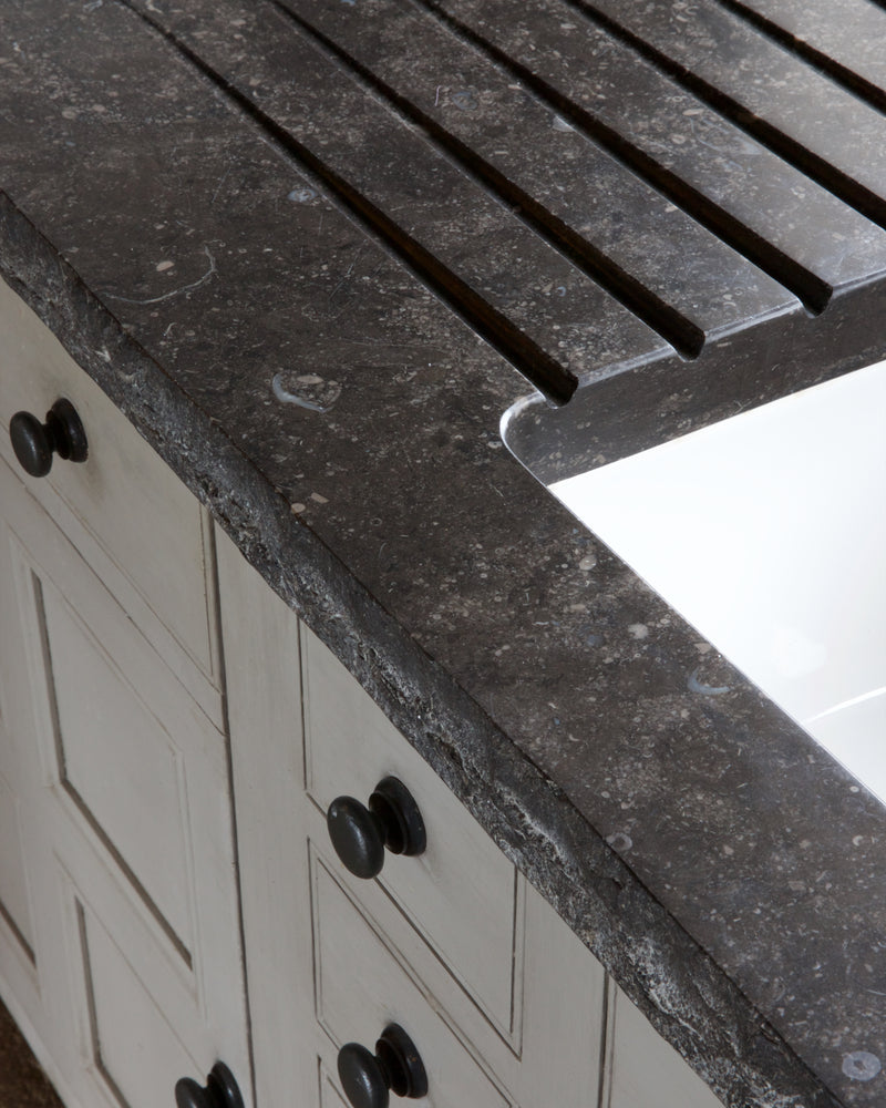 Close view of Tora Blue Honed Limestone Slab showing the hand-cut grooved drainer, the sink cutout and the chiselled front edge