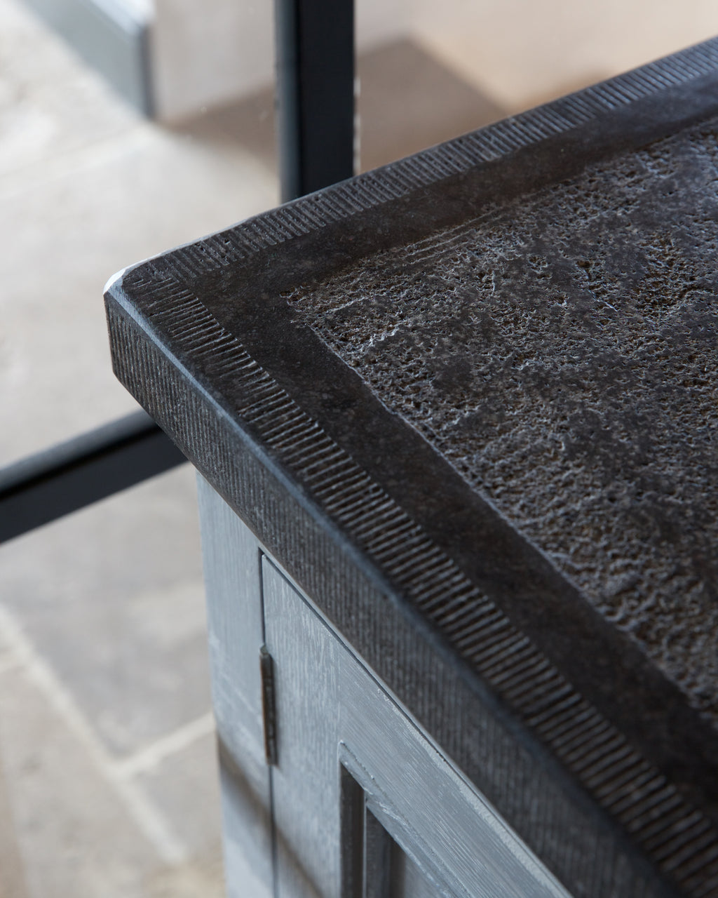 Corner detail of Tora Blue Honed Limestone Slab showing the chiselled edge profile and the fossil-flecked surface