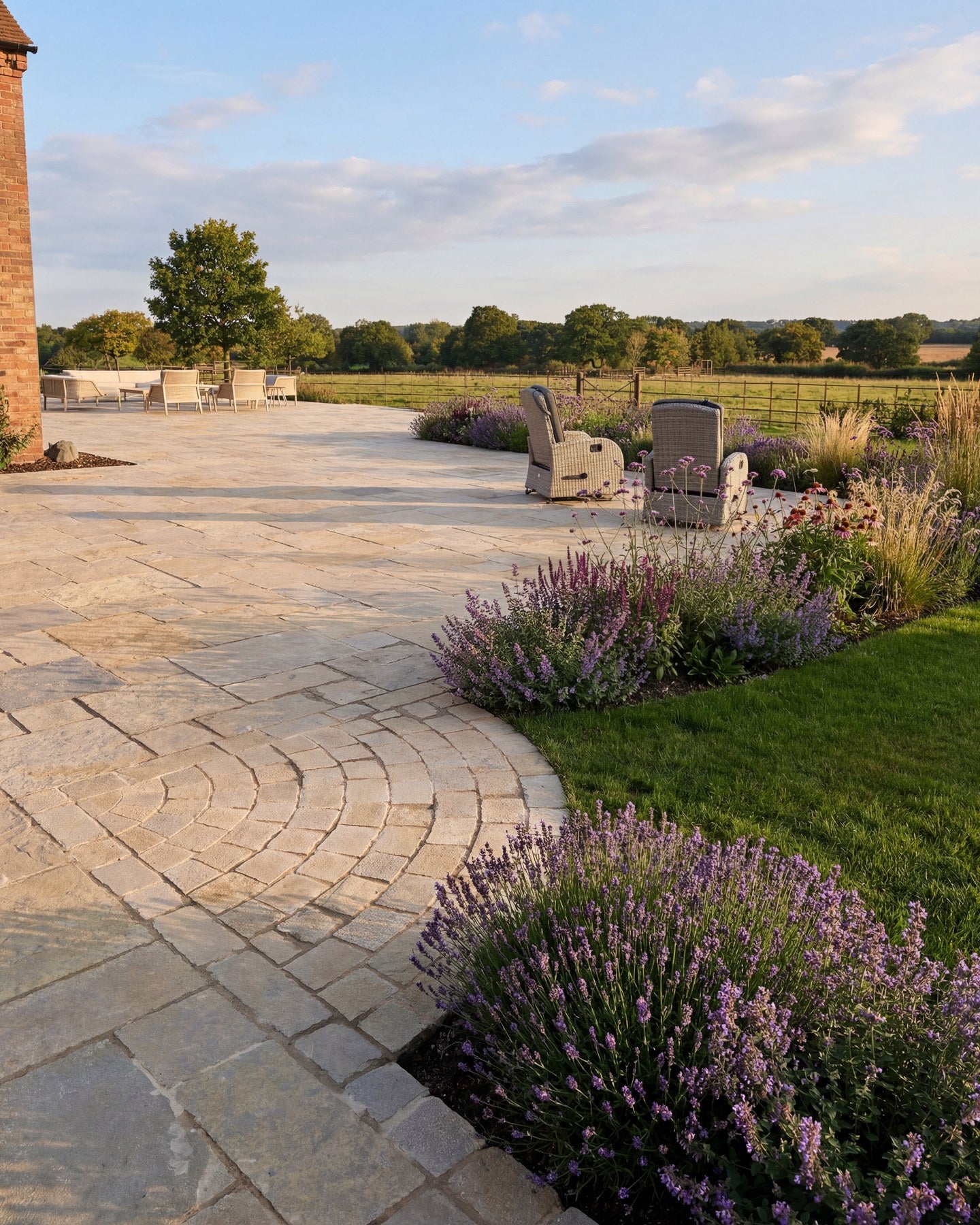 Trusloe Limestone Seasoned Finish paving with a cobble fan detail, edged by lavender borders and open countryside beyond